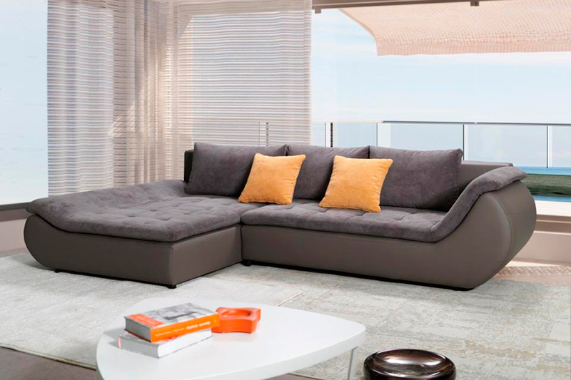 Темный диван с оранжевыми подушками