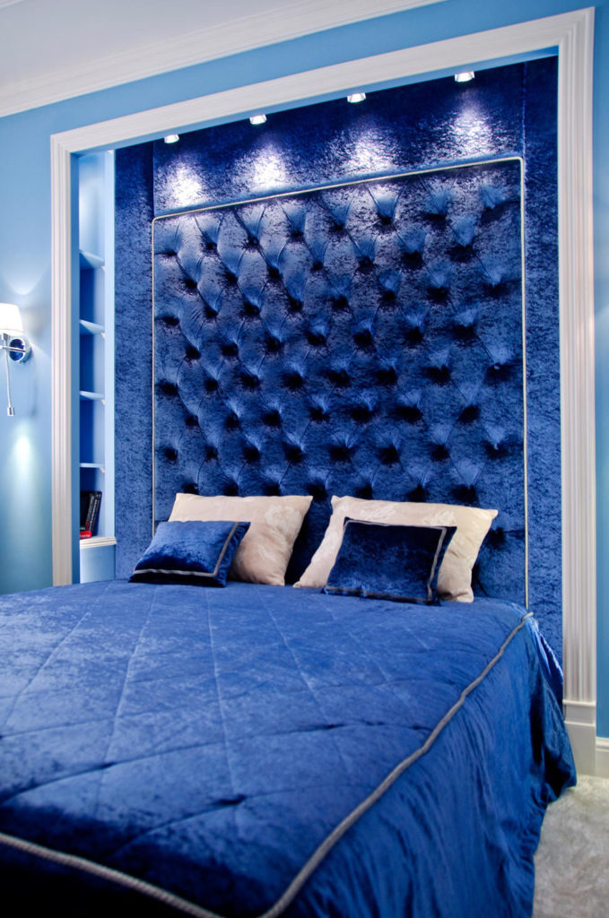 Изголовье кровати синего цвета выглядит красиво