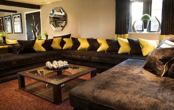 Коричневый кожаный диван в интерьере гостиной добавляет особой роскоши